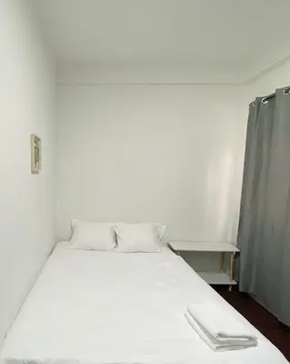 a white bed with two pillows in a room at XX GO INN Siriraj BKK - โกอินน์ ศิริราช in Bangkok Noi