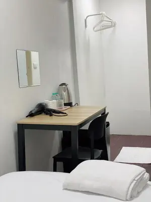 a desk in a room with a phone on it at XX GO INN Siriraj BKK - โกอินน์ ศิริราช in Bangkok Noi