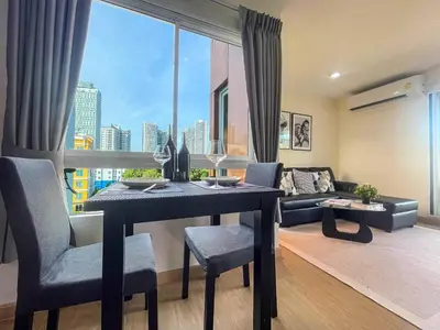 a living room with a table and a large window at Modern Cityscape1BR - Ultra Fast WiFi - BTS On nut in Bangkok