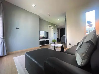 a living room with a couch and a tv at Modern Cityscape1BR - Ultra Fast WiFi - BTS On nut in Bangkok