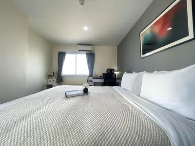 a bedroom with a bed with a book on it at Modern Cityscape1BR - Ultra Fast WiFi - BTS On nut in Bangkok