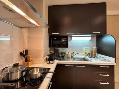 a kitchen with pots and pans on a stove at Vibrant Modern 57 SQM - Ultra Fast WiFi - BTS Thonglor in Bangkok