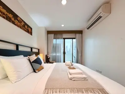 a bedroom with a large bed with towels on it at Vibrant Modern 57 SQM - Ultra Fast WiFi - BTS Thonglor in Bangkok