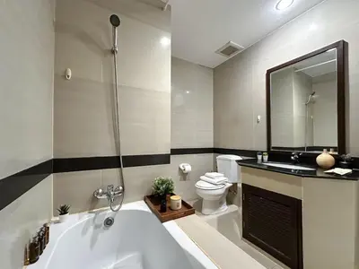 a bathroom with a tub and a toilet and a sink at Vibrant Modern 57 SQM - Ultra Fast WiFi - BTS Thonglor in Bangkok
