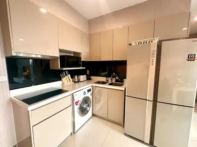 a kitchen with a refrigerator and a washing machine at Elegant & Low Rise 2 Bedrooms in Bangkok