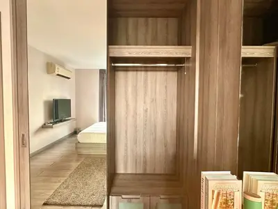 a wooden door in a room with a bedroom at Elegant & Low Rise 2 Bedrooms in Bangkok