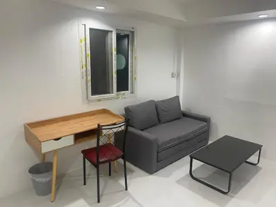 a living room with a couch and a desk at Am Am Place D Near Rajamangala in Sathani Khlong Tan