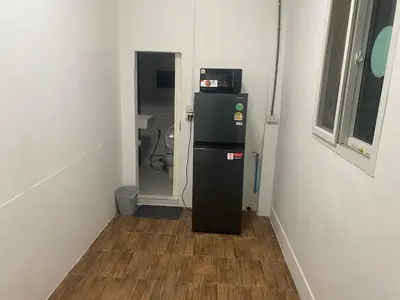 a small refrigerator in a room with a hallway at Am Am Place 2 Near Rajamangkala Stadium in Sathani Khlong Tan
