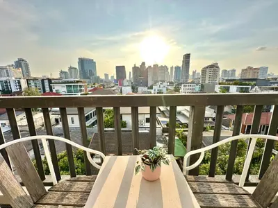 a bench on a balcony with a view of a city at Studio with view near Ekkamai in Bangkok