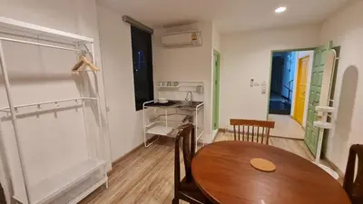 a room with a wooden table and a table and chairs at Lee Home Bangkok in Bangkok