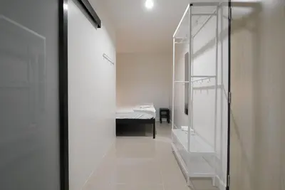 a bathroom with a walk in shower next to a bed at Lee Home Bangkok in Bangkok