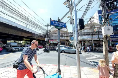 a man walking down a street with a child at The Studio at Sathorn Terrace in Bangkok