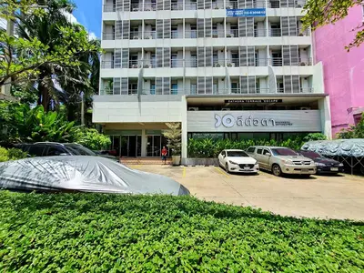 a building with cars parked in front of a parking lot at The Studio at Sathorn Terrace in Bangkok