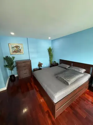 a bedroom with a large bed and a blue wall at 2 Bed Condo in the Heart of Bangkok in Bangkok