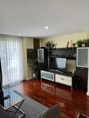 a living room with a large television and a wooden floor at 2 Bed Condo in the Heart of Bangkok in Bangkok