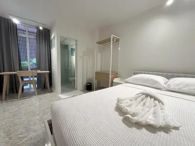 a bedroom with a white bed and a bathroom at 95 Lodge in Bangkok