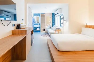 a bedroom with a bed and a living room at VELA be Bangkok Siam in Bangkok