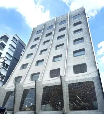 a tall white building with a fence in front of it at VELA be Bangkok Siam in Bangkok