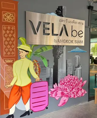 a mural of a man with a suitcase in front of a sign at VELA be Bangkok Siam in Bangkok