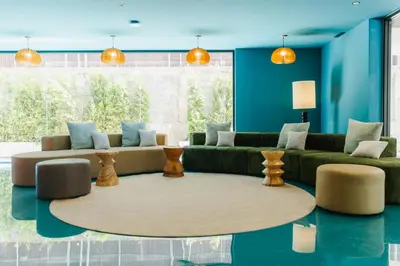 a living room with a green couch and blue walls at VELA be Bangkok Siam in Bangkok