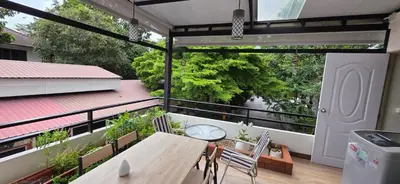 a patio with a table and chairs on a balcony at Homey Place easy access in Ban Song Hong