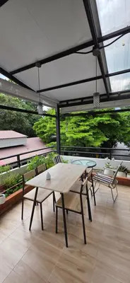 a patio with a table and chairs on a balcony at Homey Place easy access in Ban Song Hong