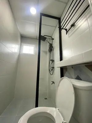 a white bathroom with a toilet and a shower at Homey Place easy access in Ban Song Hong