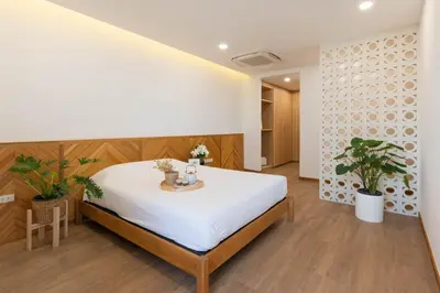 a bedroom with a large white bed and two potted plants at 3789 Elevator Villa in Bangkok