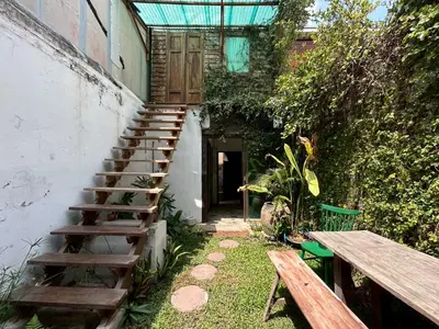 a stairway leading up to a building with a wooden bench at Yellow House in Bangkok