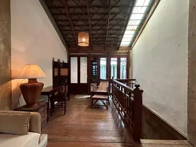 a hallway of a house with a table and chairs at Yellow House in Bangkok