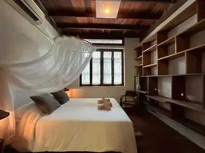 a bedroom with a bed with a mosquito net on it at Yellow House in Bangkok
