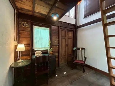 a room with a table and a chair and a window at Yellow House in Bangkok