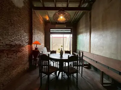 a dining room with a table and chairs and a window at Yellow House in Bangkok