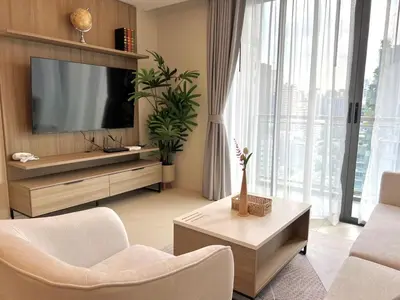 a living room with a television and a couch and chairs at Circle31 #2BR Bangkok in Bangkok