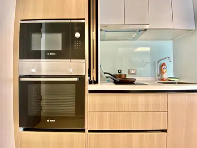 a kitchen with a stove and a microwave at Circle31 #2BR Bangkok in Bangkok