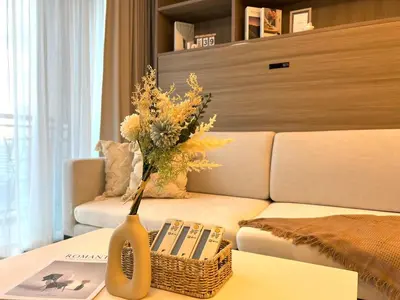 a vase with flowers on a table in a living room at Circle31 #2BR Bangkok in Bangkok
