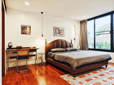 a bedroom with a bed and a desk in it at 4BR Modern Art Villa with Free Wi-Fi Netflix Vinyl in Bangkok