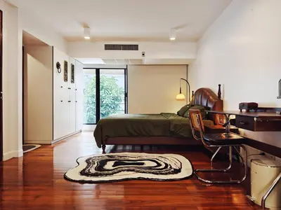 a bedroom with a bed and a desk and a rug at 4BR Modern Art Villa with Free Wi-Fi Netflix Vinyl in Bangkok