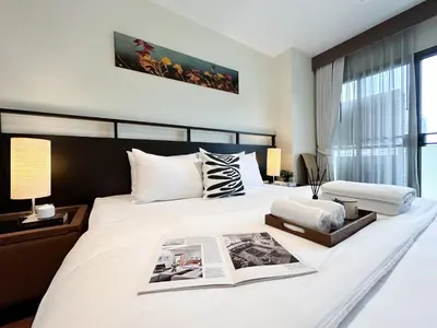 a bedroom with a large white bed and a window at Vibrant Modern 57 SQM - Ultra Fast WiFi - BTS Thonglor in Bangkok