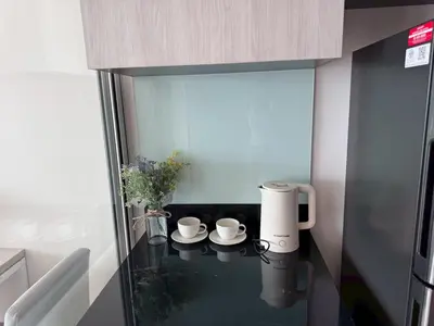 a small kitchen with a glass table with cups on it at High Floor Luxury Studio with Great Views in Bangkok