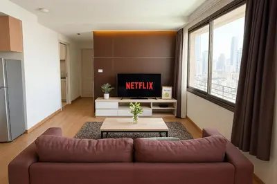 a living room with a couch and a tv at Nana SkyView Retreat 2 Bedroom 2 Bath Nana BTS in Bangkok