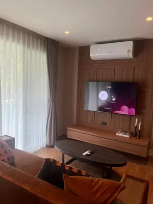 a living room with a couch and a flat screen tv at Stylish Apartment in Sukhumvit in Bangkok