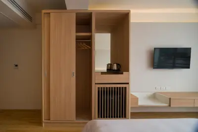 a bedroom with a cabinet with a tv in it at BEAT Warii Hostel at Chaophraya River in Bangkok