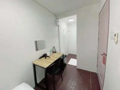 a small room with a desk and a toilet at GO INN Siriraj Wang Lang - โก อินน์ ศิริราช ตลาดวังหลัง in Bangkok Noi