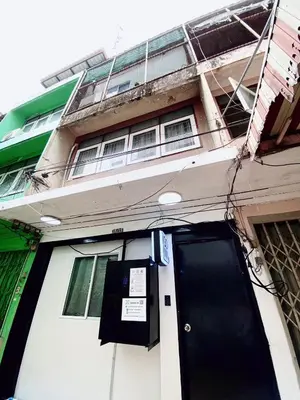 a building with a black door with a sign on it at GO INN Siriraj Wang Lang - โก อินน์ ศิริราช ตลาดวังหลัง in Bangkok Noi