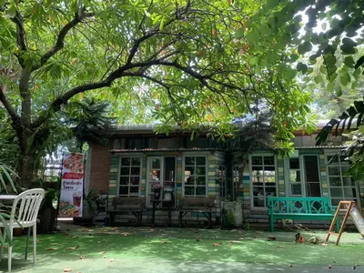 a building with tables and chairs in a yard at Ruennakornin Homestay in Ban Bang Muang