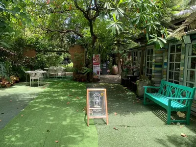 a sign in the yard with a bench and a table at Ruennakornin Homestay in Ban Bang Muang