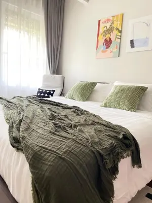 a bedroom with two white beds with green pillows at Nueng Rana 113 Unique House in Chinatown 3BR 2BA in Samphanthawong