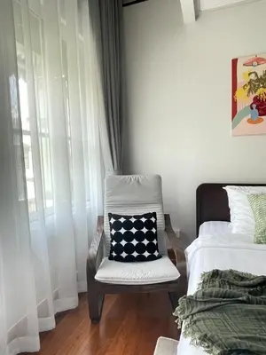 a bedroom with a chair and a bed with a pillow at Nueng Rana 113 Unique House in Chinatown 3BR 2BA in Samphanthawong