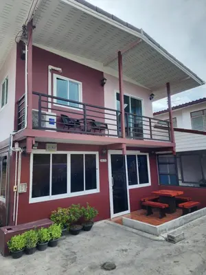 a red house with a balcony and a picnic table at Sabai - Sabai in Bangkok